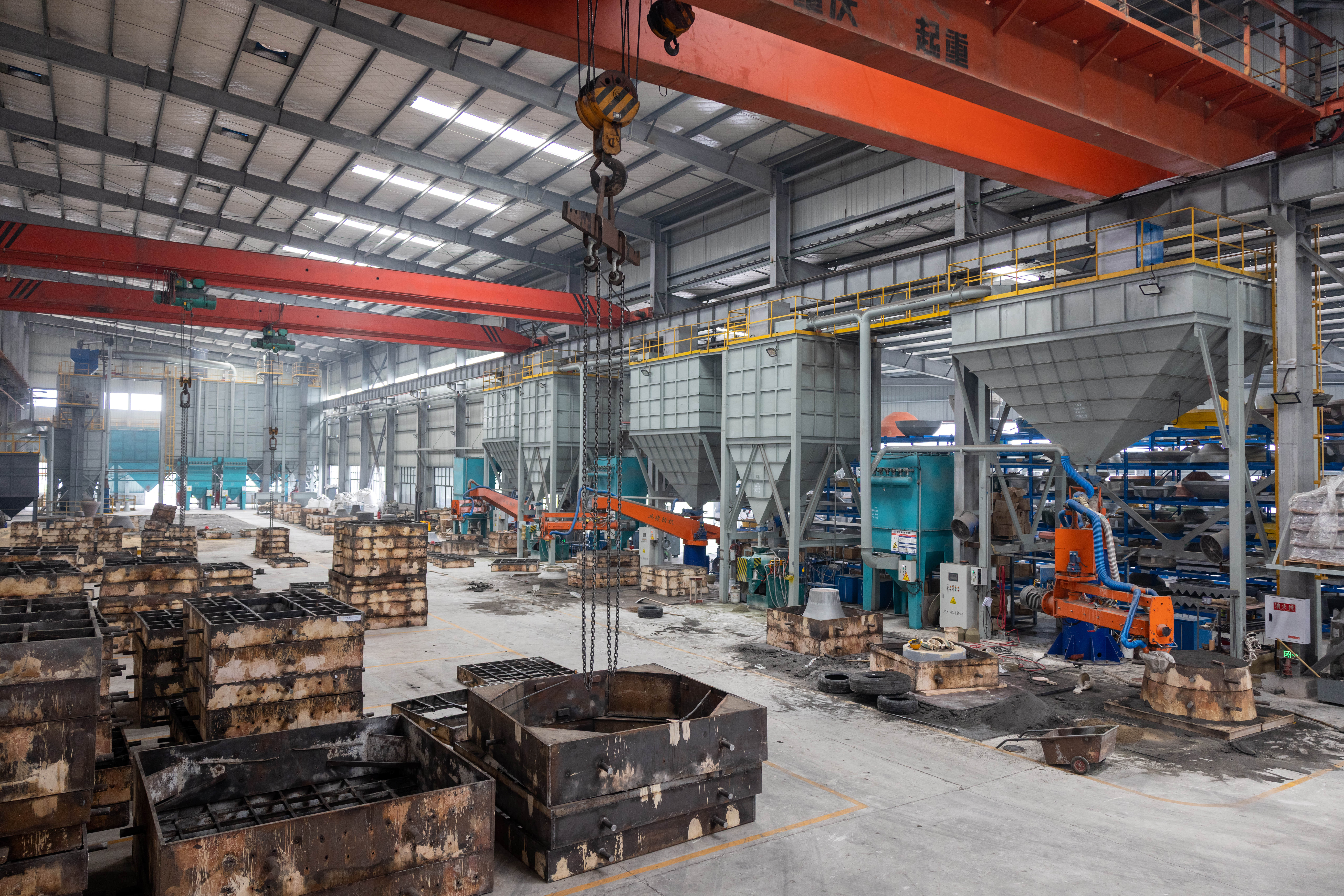 Sand molding area with mold boxes and overhead cranes
