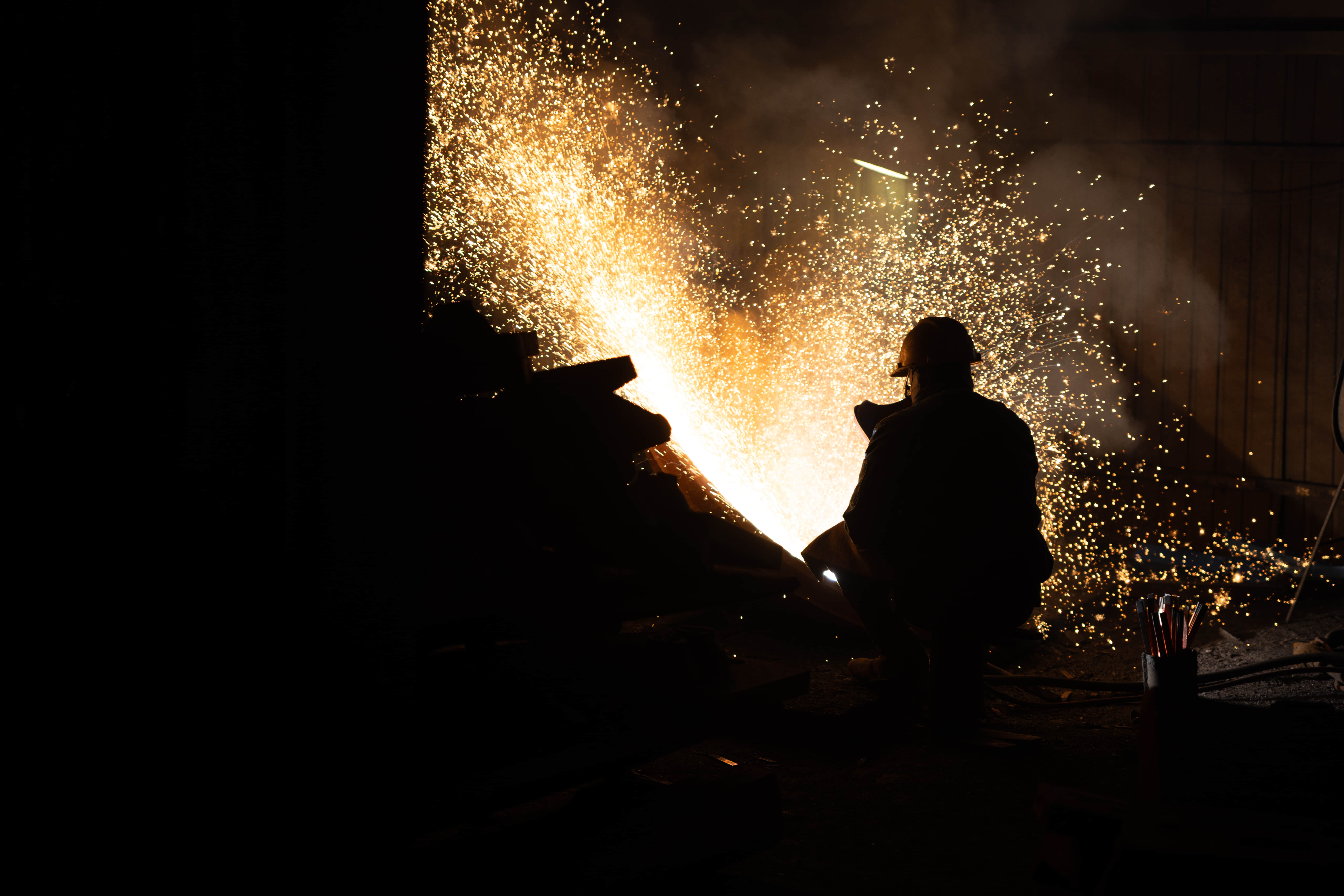 Worker grinding a casting, with sparks